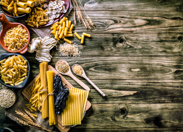 istock Italian pasta on rustic pots and wooden table in a kitchen 1026914854
