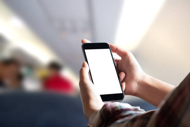 istock Airplane passenger using smart phone on plane. Businessman touching blank screen mobile phone at airplane. for graphics display montage. 1026934102