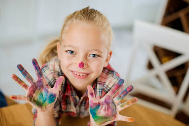 istock Cute girl with colored nose and hands 1026934252