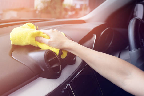 istock A man cleaning white car with yellow microfiber cloth. 1026942270