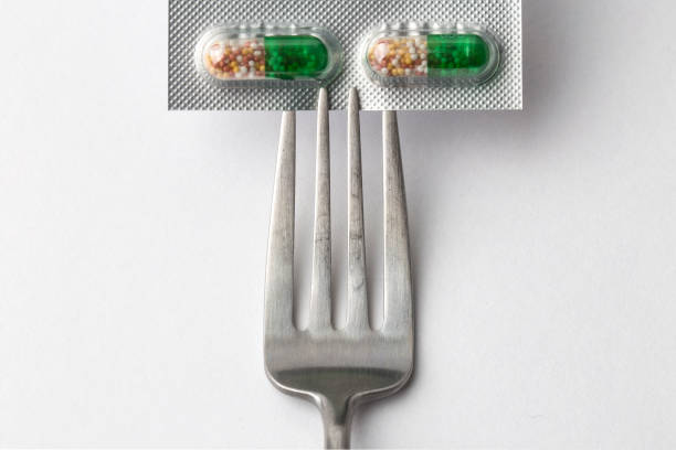 istock capsules and pills with fork, diet and weight loss, idea. Pills taken with a fork 1026942582