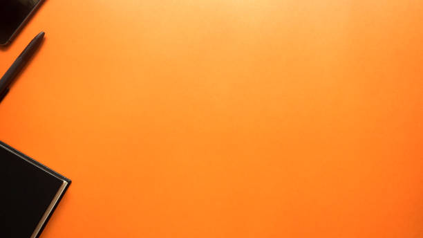 istock black pen and smartphone with notebook on orange background 1026951592