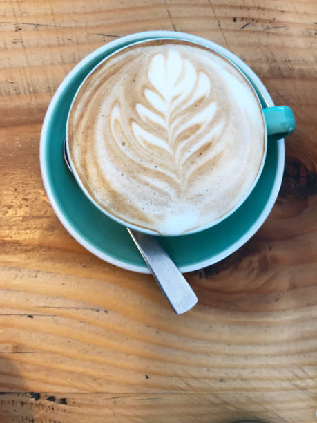 istock morning wake up by drinking a cup of coffee with milk foam leaf pattern coffee art on rustic wooden table 1026957012