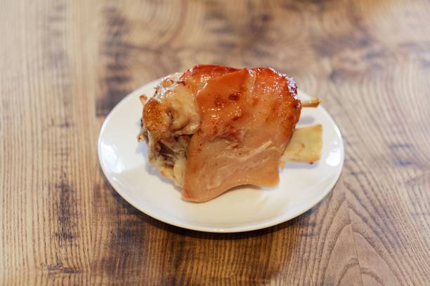 istock Eisbein (pickled ham hock) on a white plate and wooden background. 1026972766
