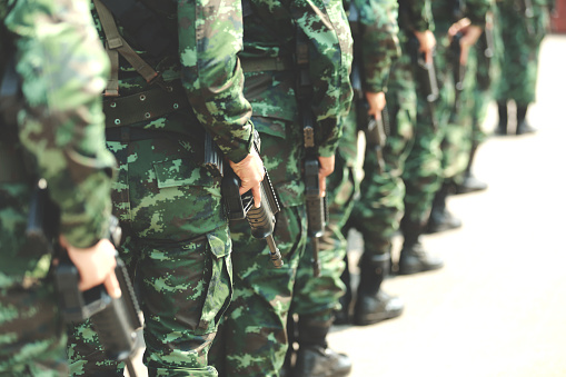 Soldiers stand in row. Gun in hand. Army, Military Boots lines of commando soldiers in camouflage uniforms Thailand