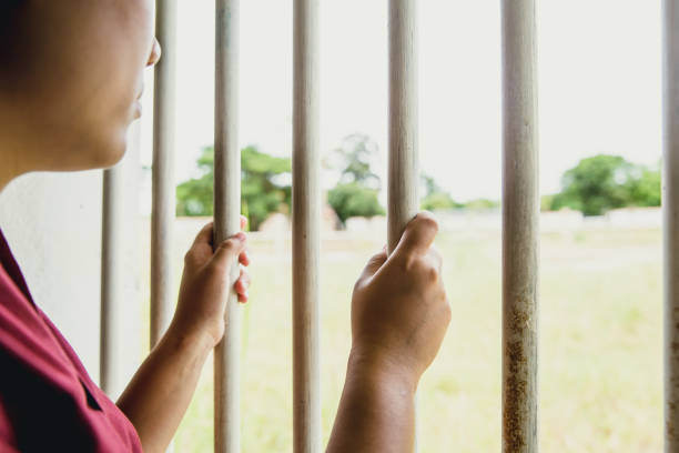 女性の権利の自由に刑務所ケージで女性刑務所不足している手がないです。 - confined space ストックフォトと画像