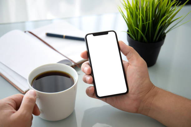 istock man hand holding phone with isolated screen in office 1026983272