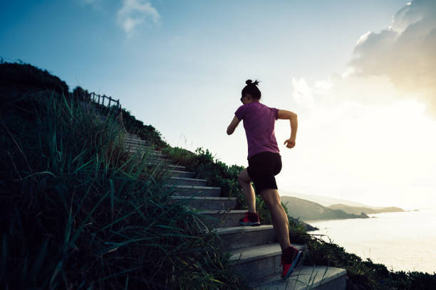 istock Woman runner running up on seaside mountain stairs 1026983284