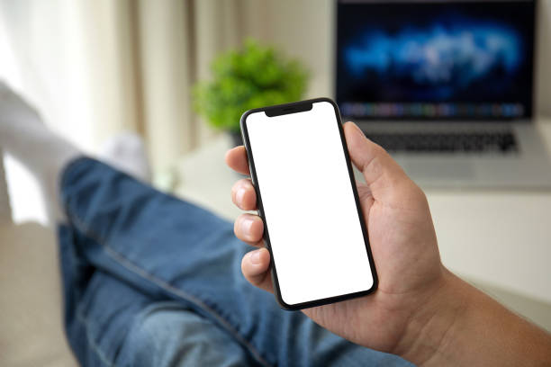 istock man on sofa holding phone with isolated screen in room house 1026985348