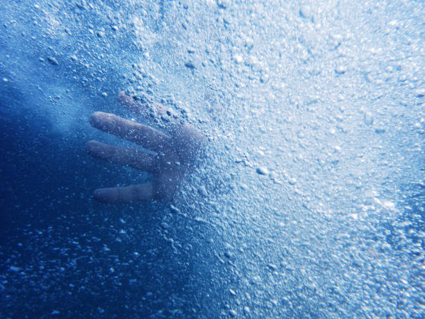istock A man's hand under the water. Bright blue water with air bubbles. Underwater shooting 1026986846