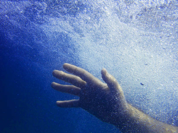 istock A man's hand under the water. Bright blue water with air bubbles. Underwater shooting 1026986960