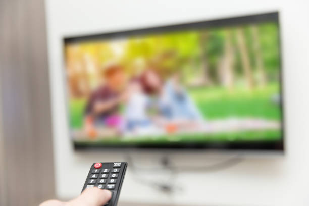 istock people watching tv hand with remote control smart television 1026993004