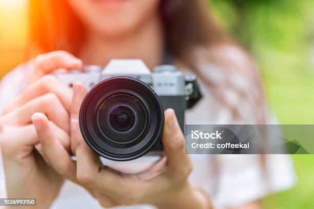 Closeup Front Lens Of Mirrorless Camera In Woman Teen Photographer Stock Photo - Download Image Now