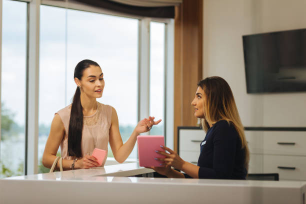 istock Nice professional administrator showing a tablet to the client 1026993254