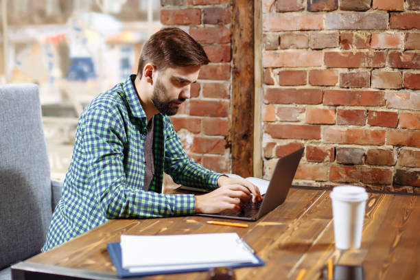 istock Young handsome man working with laptop in a cafe. 1026993402