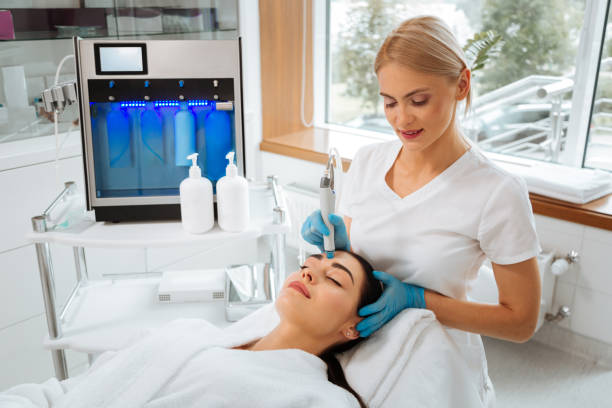 istock Professional skilled female cosmetologist doing Hydradermabrasian procedure 1026998622