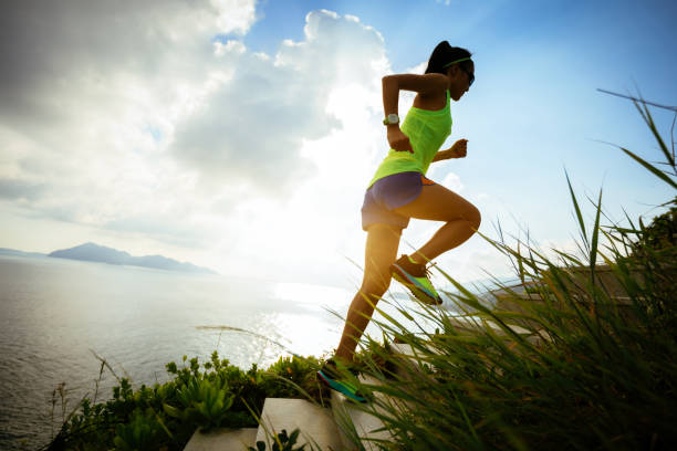 determinada mulher subindo escada de montanha à beira-mar - sunrise asia china climbing - fotografias e filmes do acervo