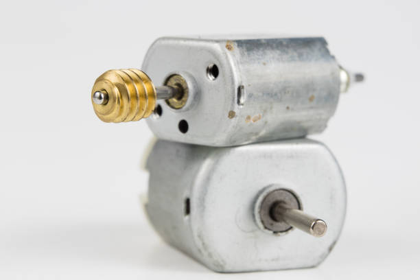Small electric motor on a white workshop table. Electric drive used in small electrical devices. Light background.