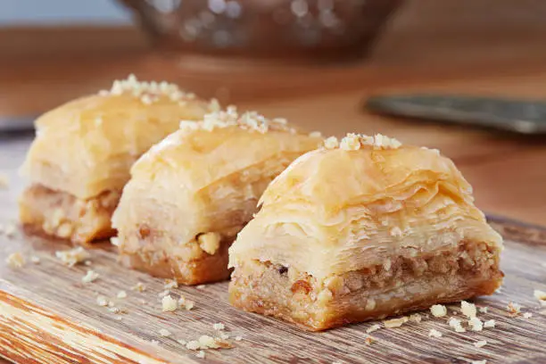 Close up shot of baklavas on the wooden background.