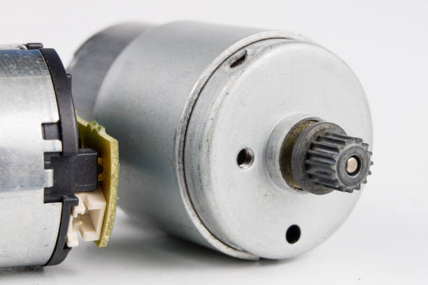 istock Small electric motor on a white workshop table. Electric drive used in small electrical devices. Light background. 1027002300