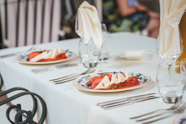 istock Table set up in a luxury restaurant. Salad with tomatoes, mozzarella and pepper. 1027009114