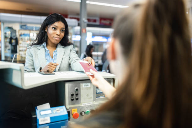 woman checking in at the airport - carteira de identidade imagens e fotografias de stock