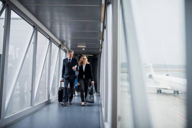 Group of people boarding a plane Group of people boarding a plane through passenger boarding bridge passenger boarding bridge stock pictures, royalty-free photos & images