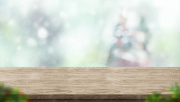 istock Empty wooden table with abstract blur christmas tree and snow falling background with bokeh,Holiday backdrop,Mock up banner for display of product for promotion online. 1027016754