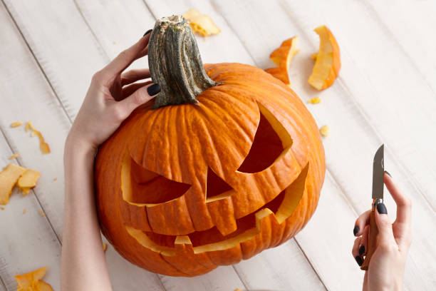 istock Carving halloween pumpkin into jack-o-lantern, close up view 1027019598