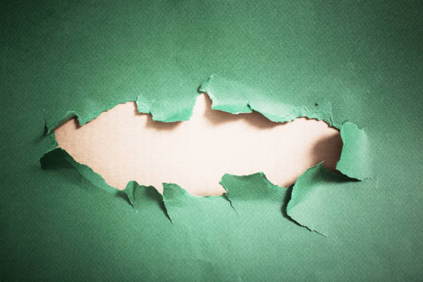 istock Hole in green paper, abstract background 1027020188