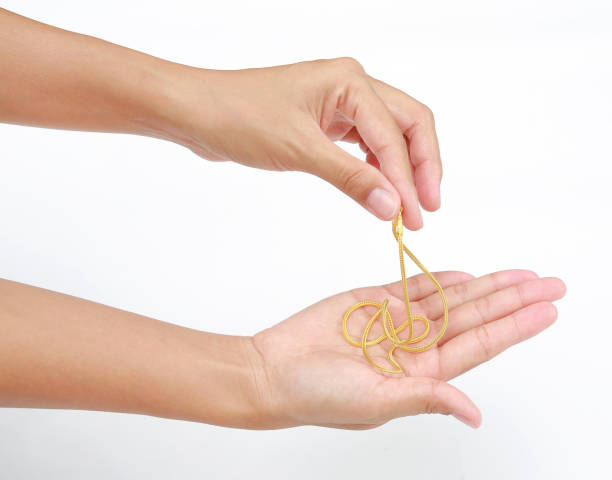 istock Close-up hands holding gold necklace on white background. 1027022794