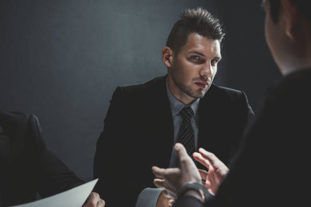 istock Detectives in interrogation room with suspect or criminal man 1027023756