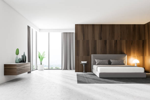 istock Dark wood and white master bedroom interior 1027026842