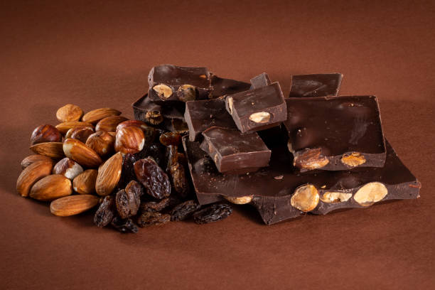 istock Stack of dark chocolate pieces with roasted almonds and raisins 1027027216
