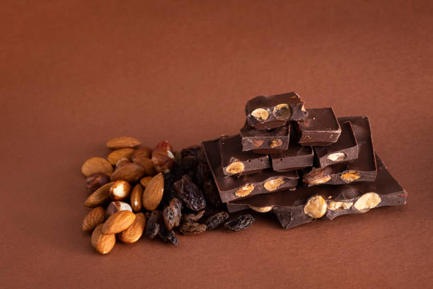 istock Stack of dark chocolate pieces with roasted almonds and raisins 1027027220