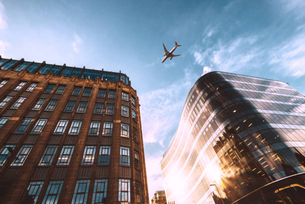 jet plane aircraft traveling in the sky over the center of glasgow city buildings. - jet way imagens e fotografias de stock