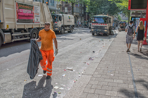Hamburg, Germany, 8/4/2018, Street cleaning after the festival. Worker and trucks on the street.
