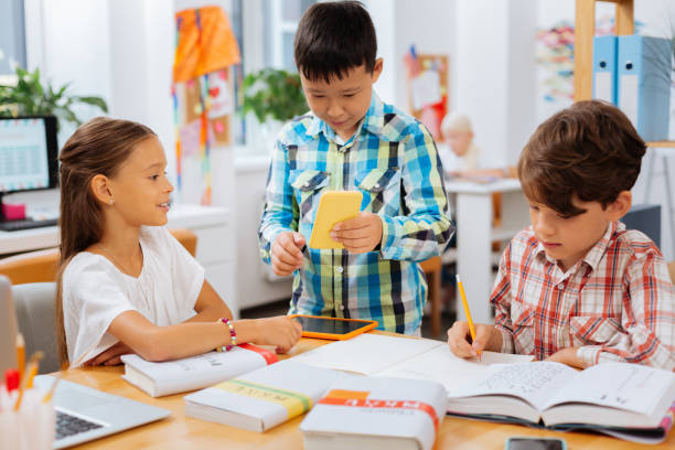istock Cheerful children sharing their notes with each other 1027033504