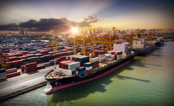 istock Logistics and transportation of Container Cargo ship and Cargo plane with working crane bridge in shipyard at sunrise, logistic import export and transport industry background 1027033634
