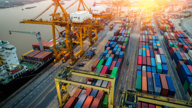 istock Logistics and transportation of Container Cargo ship and Cargo plane with working crane bridge in shipyard at sunrise, logistic import export and transport industry background 1027033658