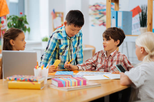 istock Interested children discussing school issues together in a classroom 1027033792