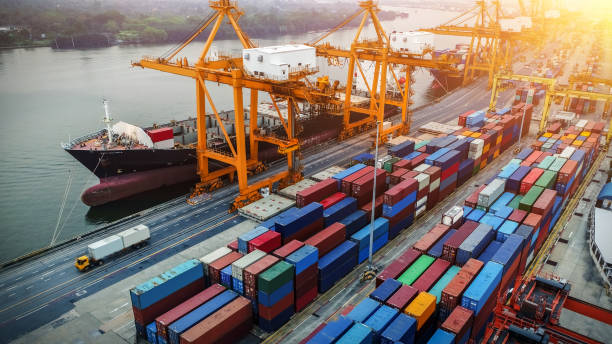 istock Logistics and transportation of Container Cargo ship and Cargo plane with working crane bridge in shipyard at sunrise, logistic import export and transport industry background 1027033794