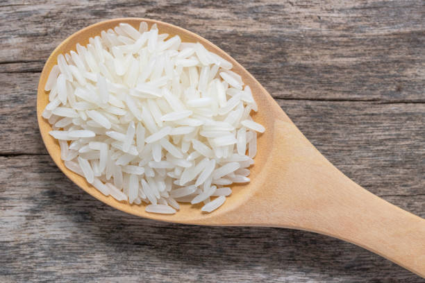istock uncook rice in wood spoon 1027036882