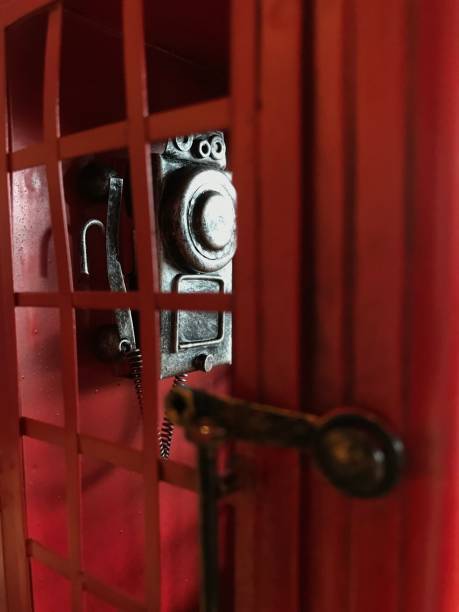 istock vintage red telephone booth with aged retro wall hanging dial phone inside. Old-fashioned decoration, furnishing design concept 1027037080