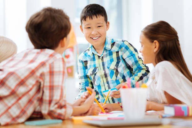 istock Cheerful boy drawing a picture with classmates 1027037206