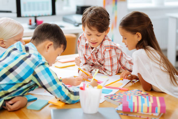 istock Classmates drawing pictures together in a classroom 1027037318