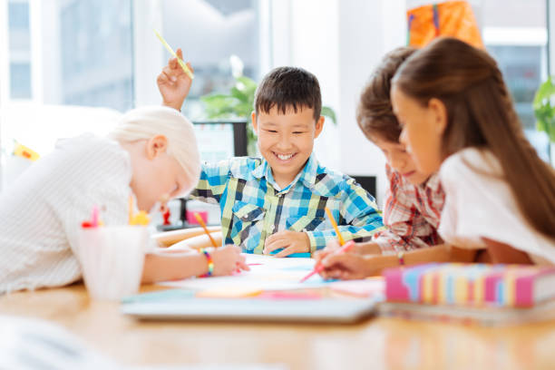 istock Excited smiling kids drawing together at school 1027037452