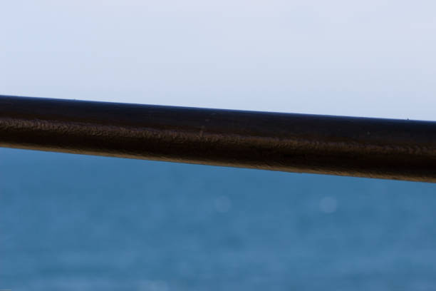istock A metal pipe dividing blue sea from grey sky 1027037530