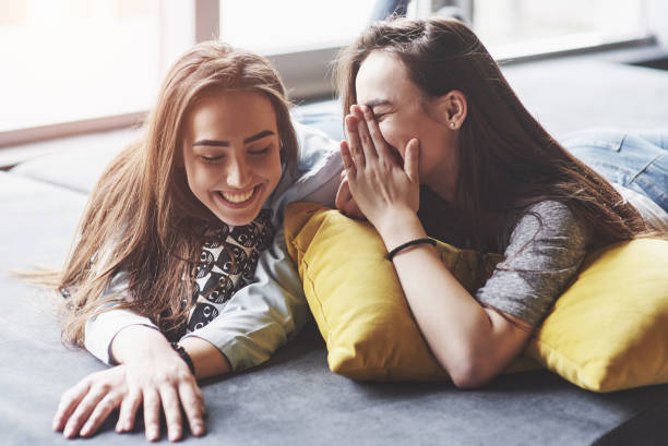 istock Two beautiful young twins sisters spending time together with pillows. Siblings having fun at home concept 1027043934