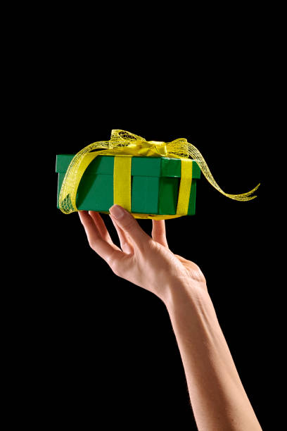 istock Hand holding green gift box with yellow ribbon 1027047418